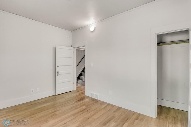 1036 12th St N, Fargo, ND 58102 - unfurnished bedroom featuring a closet, wood finished floors, ornamental molding, and baseboards