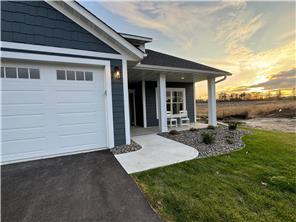 414 Ford St E, Northfield, MN 55057 - exterior entry at dusk featuring driveway, a garage, covered porch, and a yard