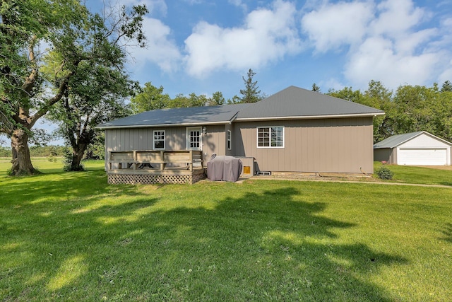 37454 605th Ave, Bluffton Twp, MN 56518 - back of house featuring a garage, a deck, a lawn, and an outbuilding