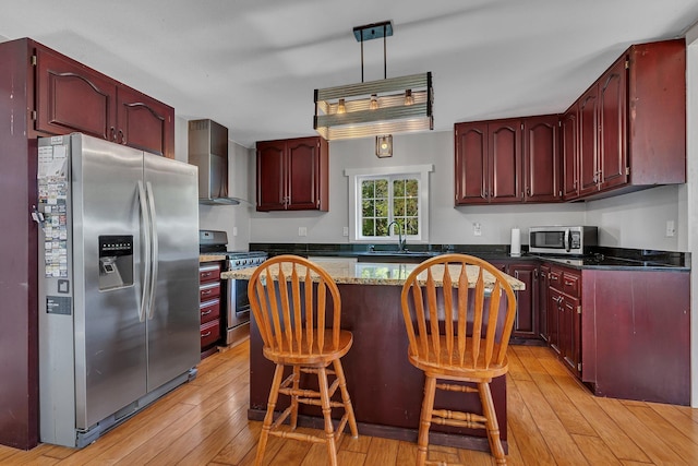 37454 605th Ave, Bluffton Twp, MN 56518 - kitchen with appliances with stainless steel finishes, dark brown cabinets, wall chimney range hood, a sink, and a kitchen island