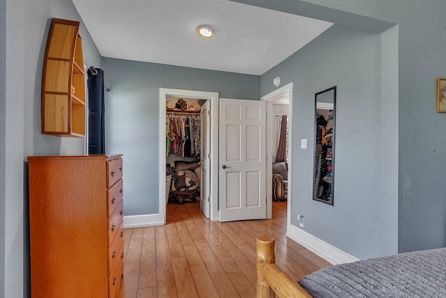 37454 605th Ave, Bluffton Twp, MN 56518 - bedroom featuring light wood-type flooring, a walk in closet, baseboards, and a closet