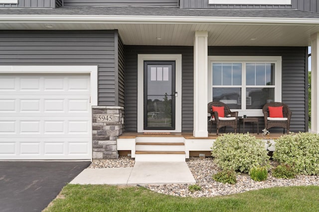 5945 178th St W, Lakeville, MN 55044 - property entrance featuring covered porch, a garage, roof with shingles, asphalt driveway, and board and batten siding