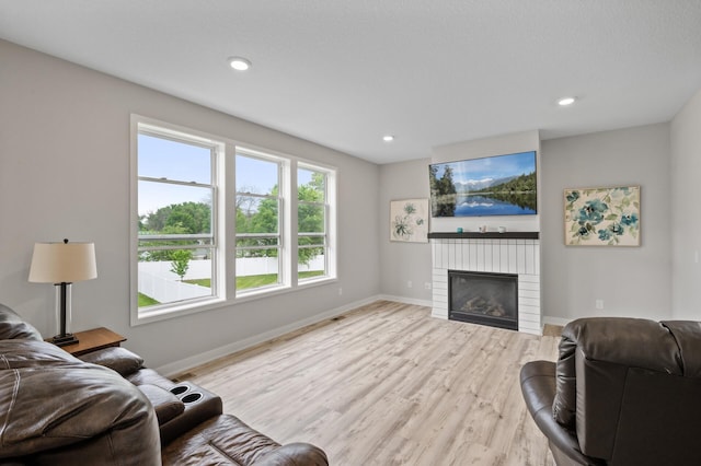 5945 178th St W, Lakeville, MN 55044 - living room with light wood finished floors, a glass covered fireplace, baseboards, and recessed lighting