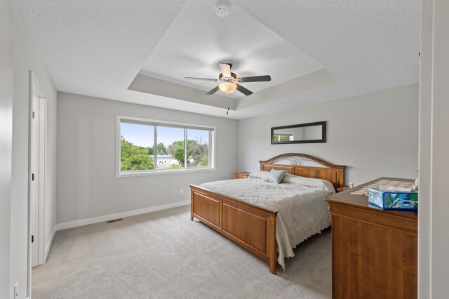 5945 178th St W, Lakeville, MN 55044 - bedroom featuring a tray ceiling, baseboards, light carpet, a textured ceiling, and a ceiling fan