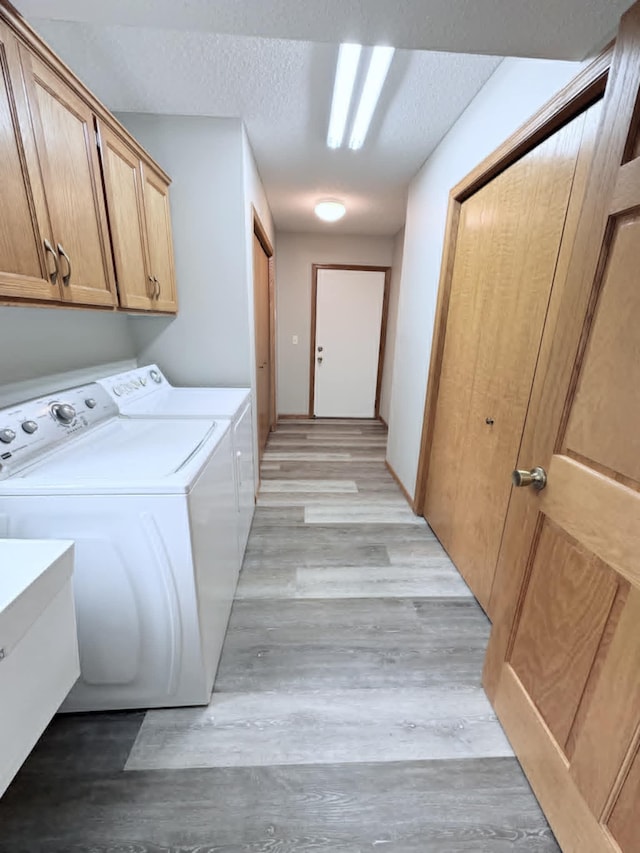 1855 Pioneer Ln Unit 1855, Centerville, MN 55038 - washroom with washer and clothes dryer, cabinet space, light wood finished floors, and a textured ceiling