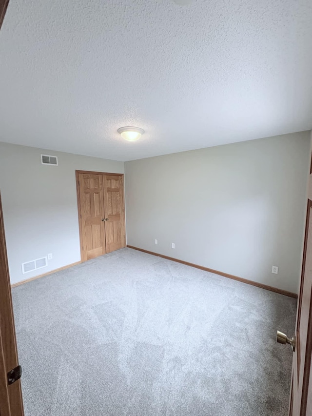 1855 Pioneer Ln Unit 1855, Centerville, MN 55038 - unfurnished bedroom with a textured ceiling, light carpet, and a closet