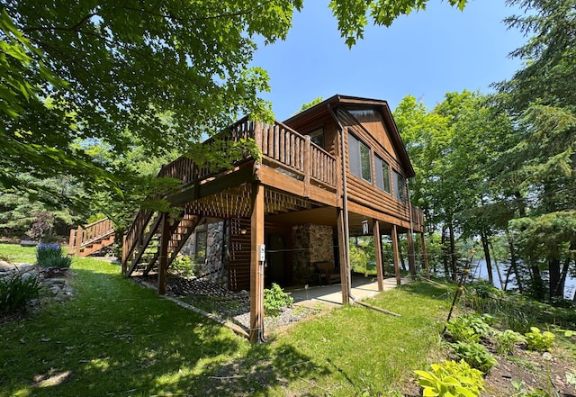 27315 Stark Lake Rd, Aitkin, MN 56431 - rear view of house featuring a wooden deck, a lawn, stone siding, and a patio area