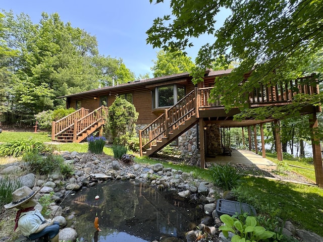 27315 Stark Lake Rd, Aitkin, MN 56431 - back of property featuring stairway, a wooden deck, and a small pond