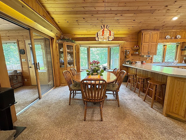 27315 Stark Lake Rd, Aitkin, MN 56431 - dining space featuring light carpet, wood ceiling, wooden walls, and vaulted ceiling