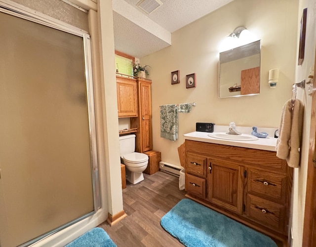 27315 Stark Lake Rd, Aitkin, MN 56431 - full bathroom featuring a shower stall, vanity, wood finished floors, a textured ceiling, and baseboard heating