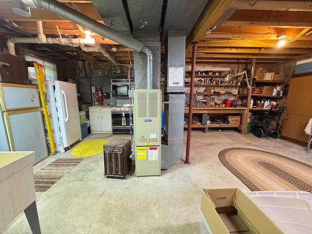 27315 Stark Lake Rd, Aitkin, MN 56431 - unfinished basement with heating unit, freestanding refrigerator, a workshop area, and electric panel