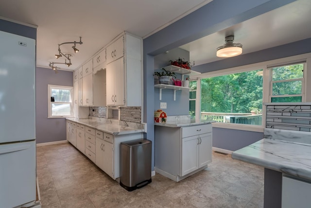 43867 County Road 15, New Sweden Twp, MN 56074 - kitchen with freestanding refrigerator, tasteful backsplash, white cabinets, and light stone countertops