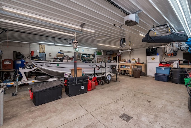 43867 County Road 15, New Sweden Twp, MN 56074 - garage featuring a workshop area, freestanding refrigerator, and a garage door opener