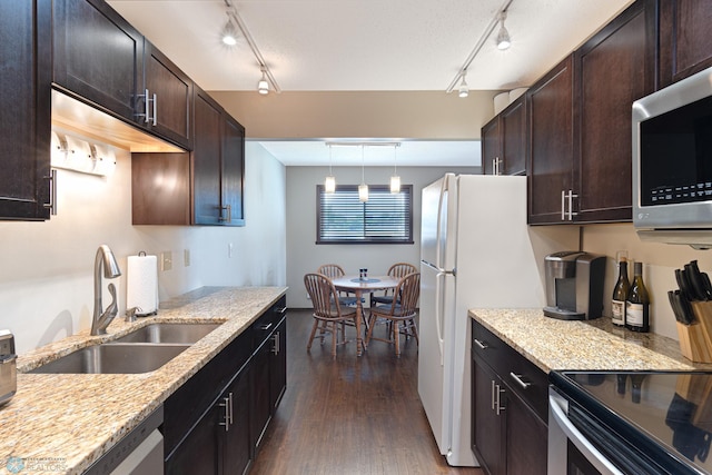 1129 22nd St S Unit B12, Fargo, ND 58103 - kitchen with appliances with stainless steel finishes, rail lighting, dark wood-style floors, dark brown cabinetry, and light stone counters