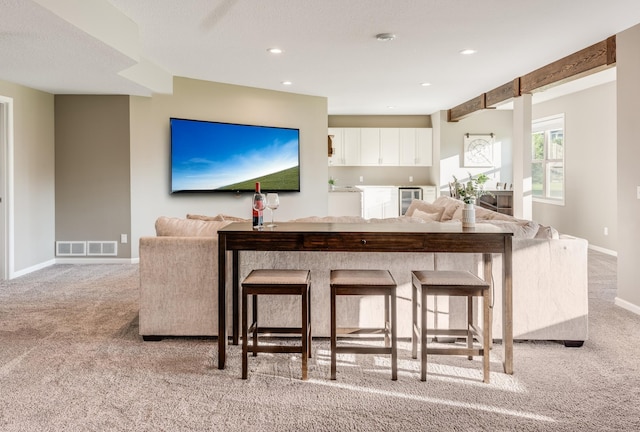 10329 Kentucky Ave N, Brooklyn Park, MN 55445 - kitchen with light colored carpet, beverage cooler, white cabinetry, open floor plan, and recessed lighting