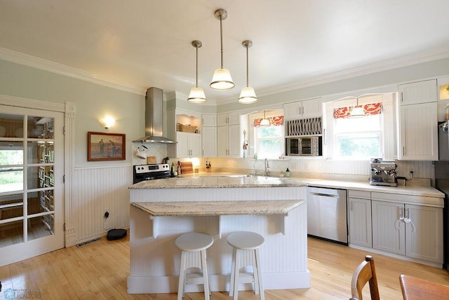 5560 County Road 3, Kindred, ND 58051 - kitchen with stainless steel appliances, wall chimney range hood, a kitchen island, light wood-type flooring, and crown molding
