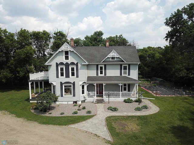 5560 County Road 3, Kindred, ND 58051 - victorian home featuring covered porch, a chimney, a front yard, and a shingled roof