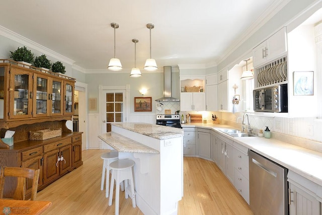 5560 County Road 3, Kindred, ND 58051 - kitchen with wall chimney range hood, stainless steel appliances, a sink, a kitchen island, and light wood finished floors