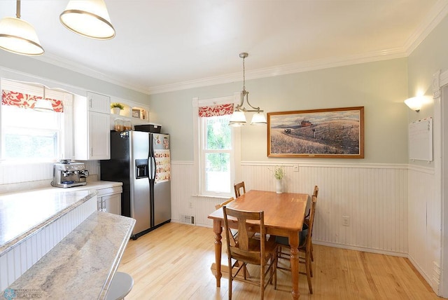 5560 County Road 3, Kindred, ND 58051 - dining area with a wainscoted wall, light wood-type flooring, and crown molding