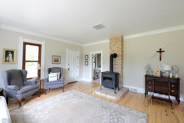 5560 County Road 3, Kindred, ND 58051 - living area with crown molding, a wood stove, light wood-style flooring, and baseboards