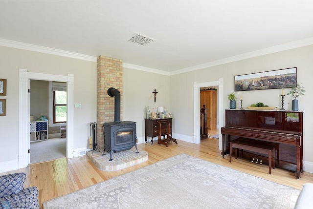 5560 County Road 3, Kindred, ND 58051 - living area with a wood stove, wood finished floors, crown molding, and baseboards