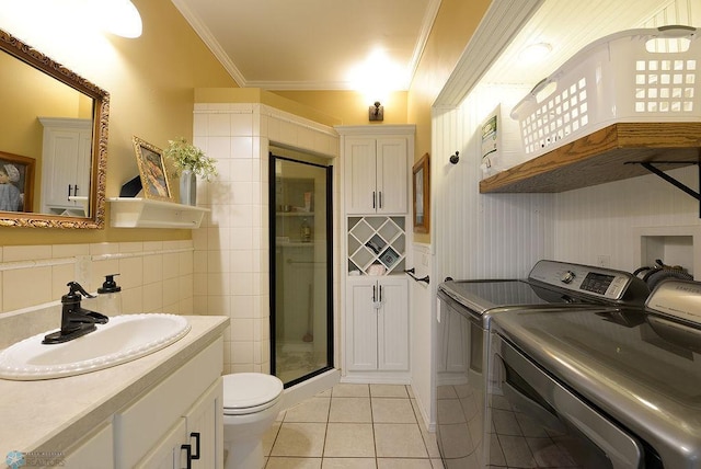 5560 County Road 3, Kindred, ND 58051 - laundry room featuring washing machine and clothes dryer, light tile patterned floors, and crown molding