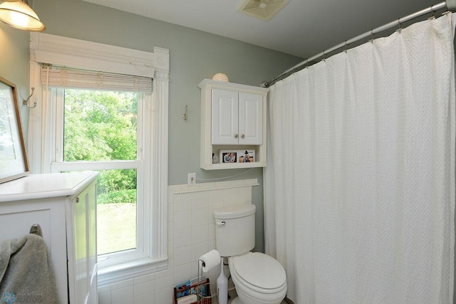5560 County Road 3, Kindred, ND 58051 - bathroom with toilet, tile walls, wainscoting, and a shower with curtain