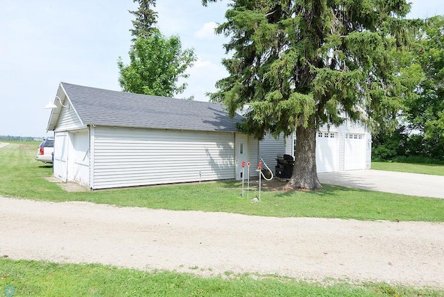 5560 County Road 3, Kindred, ND 58051 - exterior space with roof with shingles, a garage, and a yard