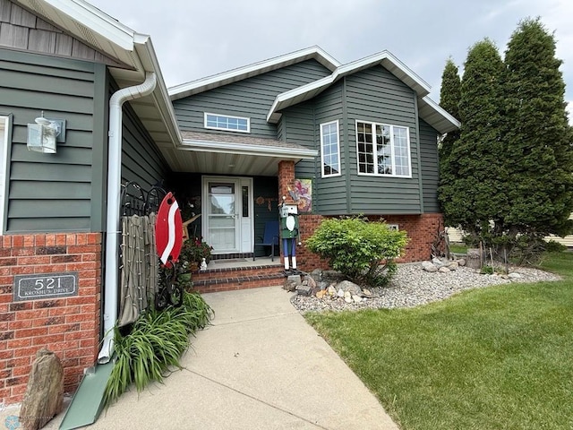 521 Kroshus Dr, Dilworth, MN 56529 - property entrance featuring brick siding and a lawn