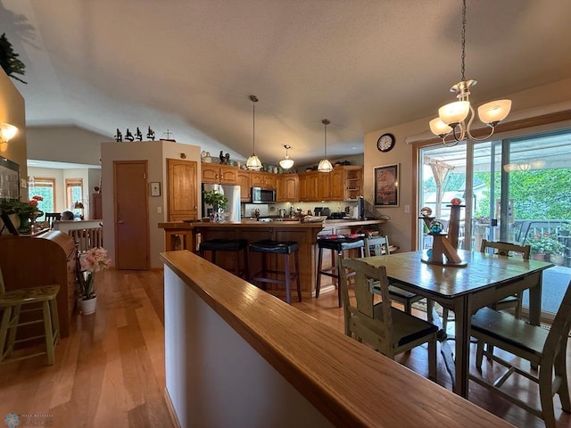 521 Kroshus Dr, Dilworth, MN 56529 - dining space with light wood finished floors, a chandelier, and vaulted ceiling