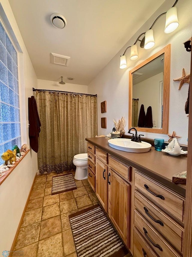 521 Kroshus Dr, Dilworth, MN 56529 - full bath with vanity, toilet, stone finish flooring, baseboards, and a shower with shower curtain