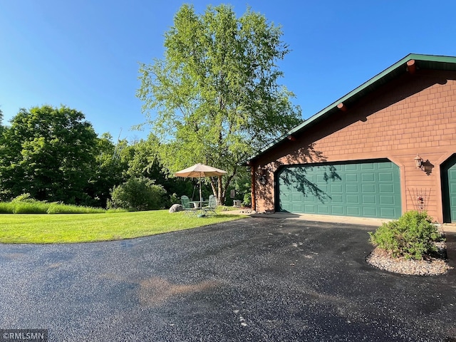 37760 Dove St Unit 14, Aitkin, MN 56431 - view of property exterior with asphalt driveway, a yard, and a garage