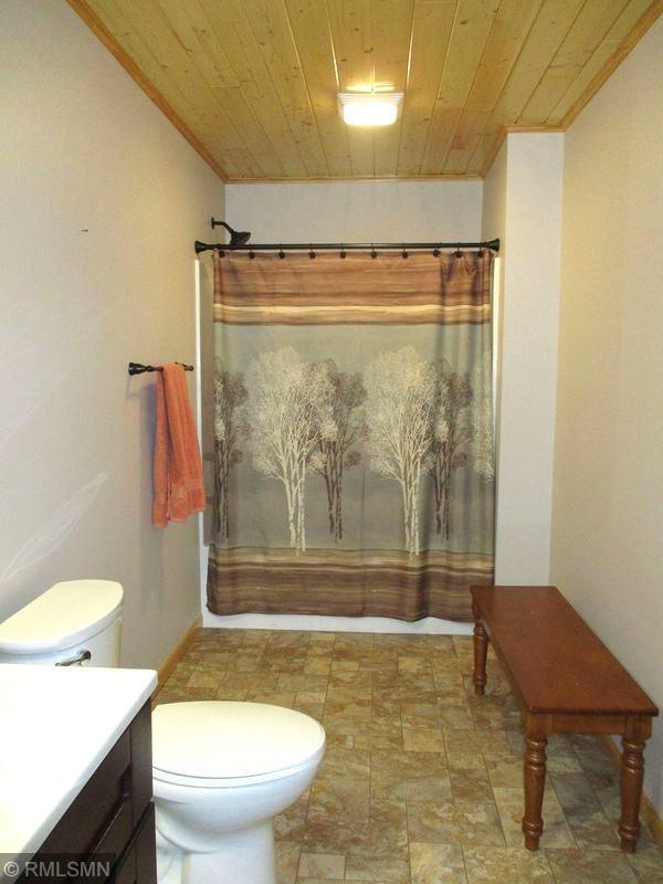 37760 Dove St Unit 14, Aitkin, MN 56431 - full bath featuring vanity, wood ceiling, stone finish floors, and ornamental molding