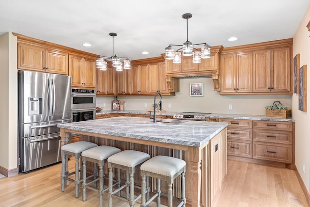 3546 230th St E, Prior Lake, MN 55372 - kitchen featuring stainless steel appliances, light wood-style floors, a center island with sink, a kitchen bar, and recessed lighting