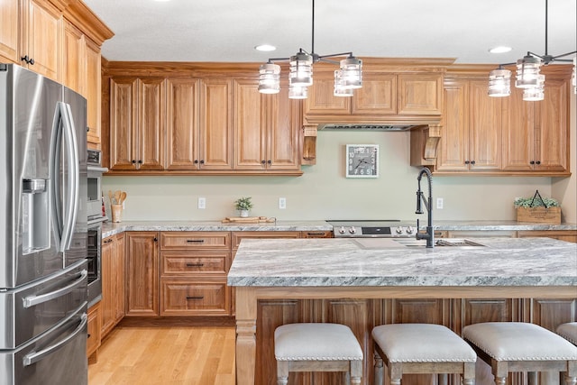 3546 230th St E, Prior Lake, MN 55372 - kitchen featuring stainless steel appliances, a breakfast bar, light wood-style flooring, light stone counters, and pendant lighting