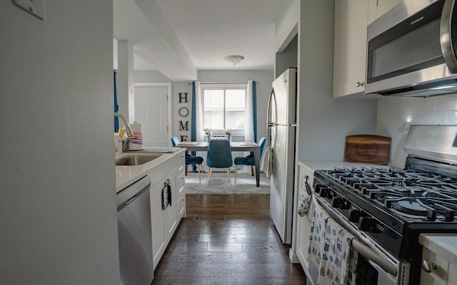 6303 84th Ct N, Brooklyn Park, MN 55445 - kitchen with stainless steel appliances, dark wood-type flooring, tasteful backsplash, and light countertops