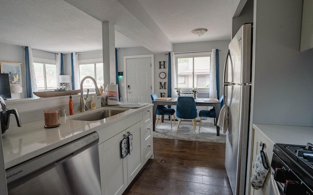 6303 84th Ct N, Brooklyn Park, MN 55445 - kitchen with stainless steel appliances, white cabinetry, dark wood-style floors, light stone counters, and a textured ceiling