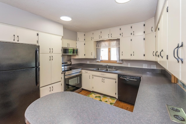 471 Tyrol Dr, Brainerd, MN 56401 - kitchen with black appliances, a sink, dark countertops, and a peninsula