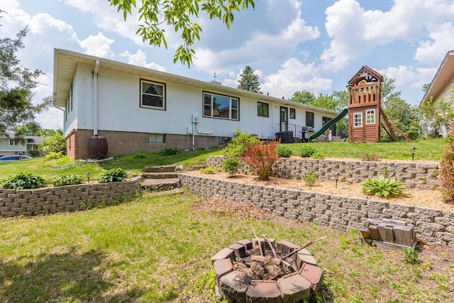 471 Tyrol Dr, Brainerd, MN 56401 - back of property with a fire pit, a yard, and a playground