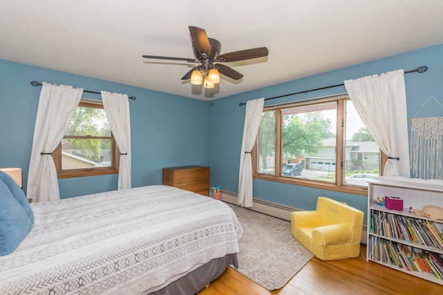 471 Tyrol Dr, Brainerd, MN 56401 - bedroom with wood finished floors, ceiling fan, baseboards, and a baseboard heating unit