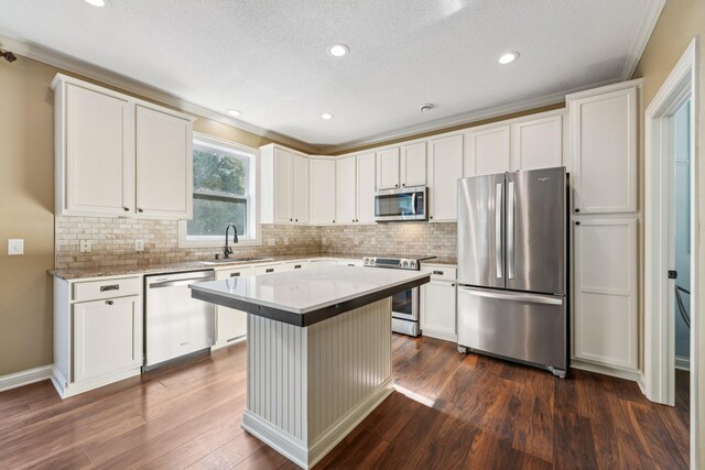 1741 Prescott Ln, Chaska, MN 55318 - kitchen featuring appliances with stainless steel finishes, a sink, dark wood-style flooring, tasteful backsplash, and a kitchen island