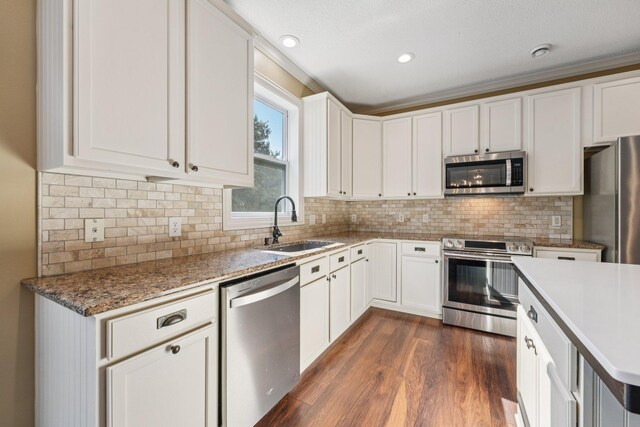 1741 Prescott Ln, Chaska, MN 55318 - kitchen with stainless steel appliances, a sink, dark wood-type flooring, white cabinets, and recessed lighting