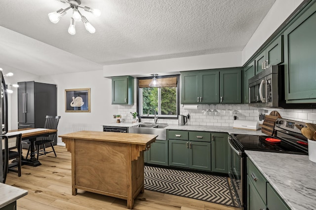 3717 80th Ave N, Brooklyn Park, MN 55443 - kitchen featuring green cabinets, appliances with stainless steel finishes, light wood-style flooring, and a textured ceiling