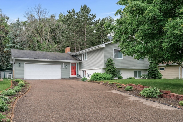 3717 80th Ave N, Brooklyn Park, MN 55443 - split level home featuring asphalt driveway, a chimney, a garage, and a front yard