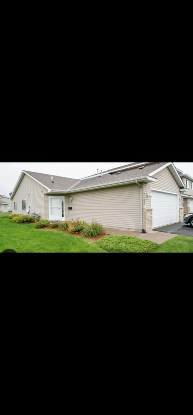 2145 Cleveland Way S, Cambridge, MN 55008 - view of front of property featuring a garage, a front lawn, and asphalt driveway