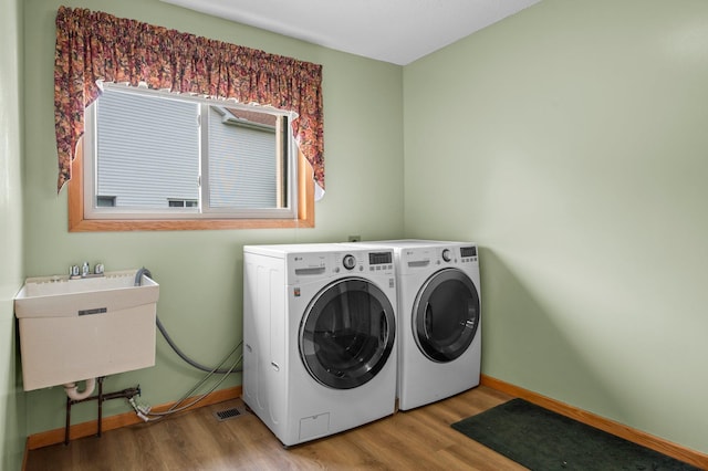 13842 Redwood St NW, Andover, MN 55304 - washroom with washer and clothes dryer, light wood-style floors, and baseboards