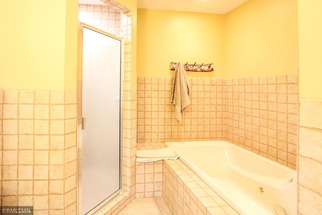 49063 203rd Pl, Mcgregor, MN 55760 - bathroom featuring tile walls, a shower stall, a garden tub, tile patterned floors, and wainscoting