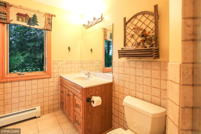 49063 203rd Pl, Mcgregor, MN 55760 - bathroom featuring a baseboard heating unit, tile walls, vanity, toilet, and wainscoting
