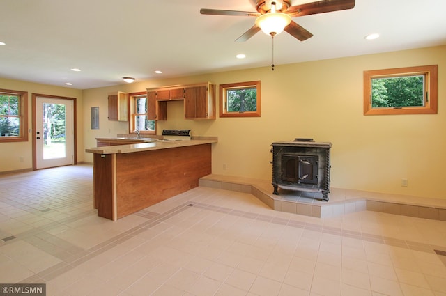 49063 203rd Pl, Mcgregor, MN 55760 - kitchen featuring a wood stove, a peninsula, recessed lighting, a ceiling fan, and a sink