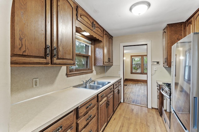 5420 Fremont Ave N, Brooklyn Center, MN 55430 - kitchen featuring stainless steel appliances, a sink, light wood-style floors, light countertops, and baseboards